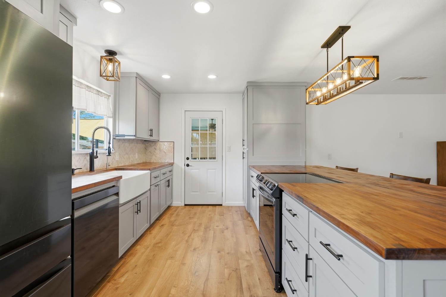 289 West Cypress Avenue Reedley, CA 93654 - Photo 6 of 45 a kitchen with a stove a sink and a refrigerator