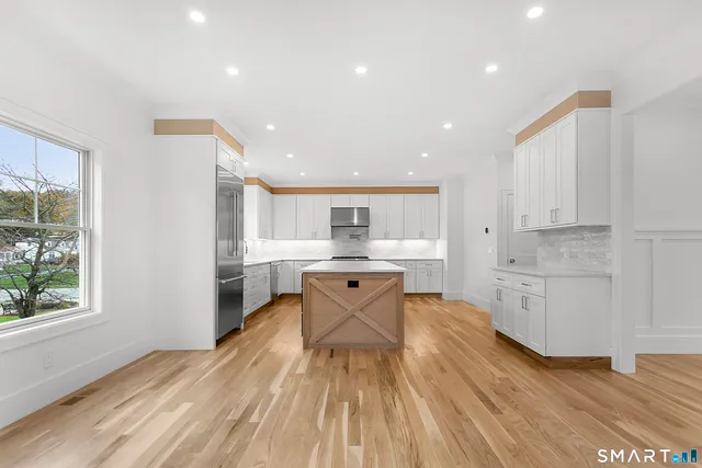a kitchen with a sink wooden floor and view living room