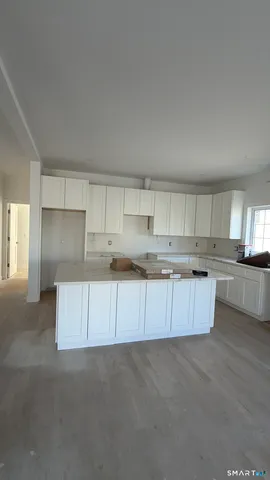 a view of kitchen with kitchen island and white cabinets