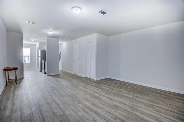 a view of empty room with wooden floor