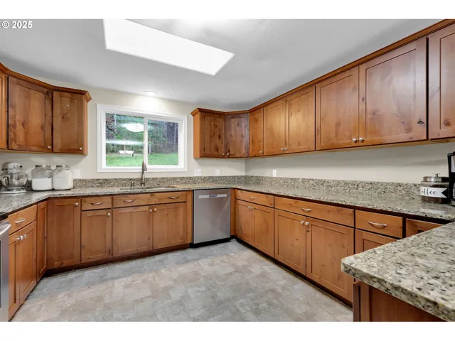 a kitchen with stainless steel appliances granite countertop wooden cabinets a sink and a stove