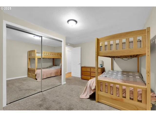 a bedroom with a bed a mirror and lamp