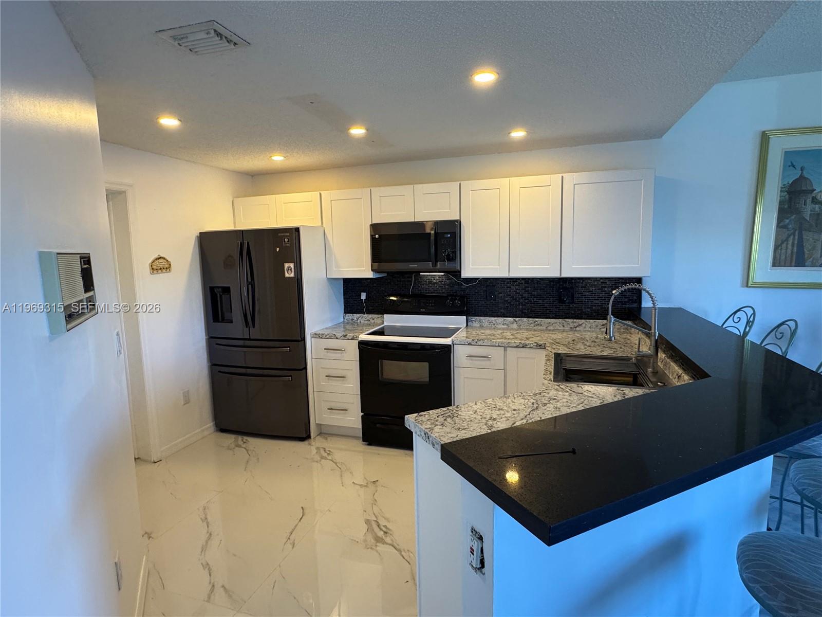 15490 Southwest 47th Street Miami, FL 33185 - Photo 18 of 43 a kitchen with stainless steel appliances a refrigerator a stove a microwave a sink and a refrigerator