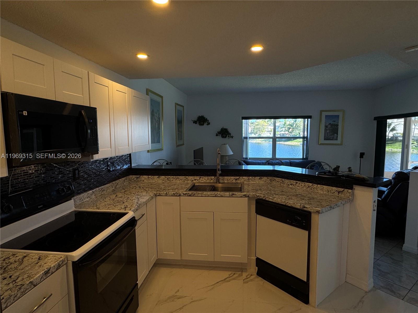 15490 Southwest 47th Street Miami, FL 33185 - Photo 19 of 43 a kitchen with a sink and a stove top oven with wooden floor