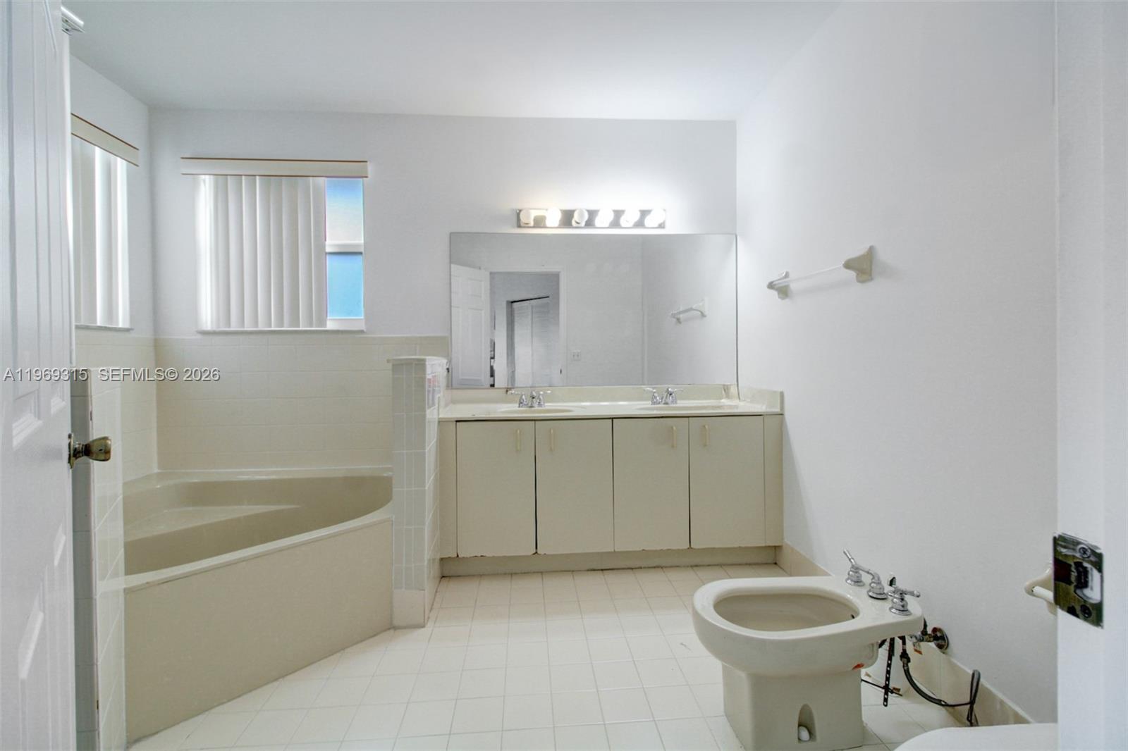 15490 Southwest 47th Street Miami, FL 33185 - Photo 28 of 43 a bathroom with a sink a mirror a bathtub and a shower