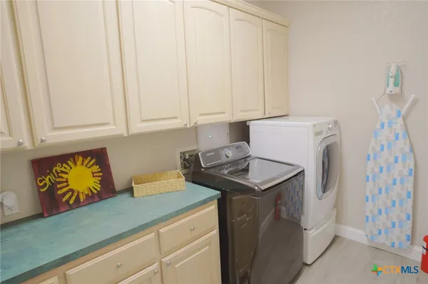 a utility room with fridge and washer