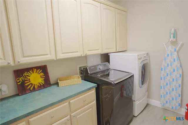 a utility room with fridge and washer