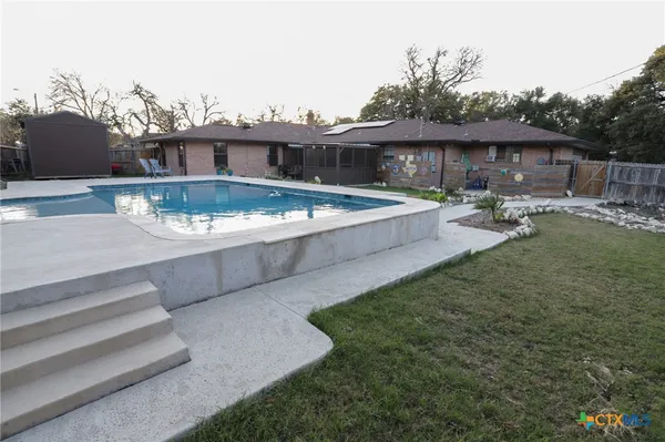 a view of a house with backyard and sitting area