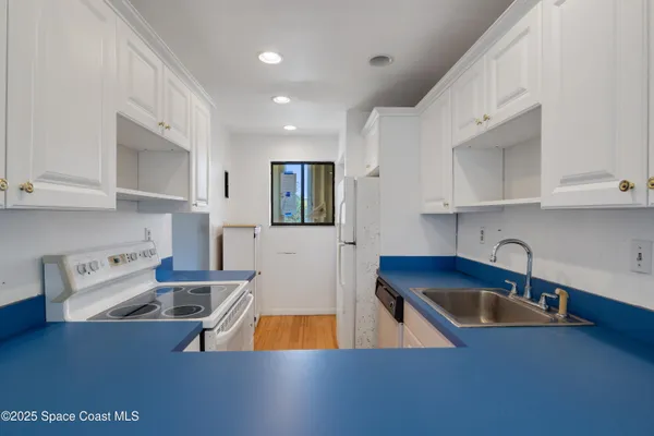a kitchen with stainless steel appliances granite countertop a sink a stove and a refrigerator
