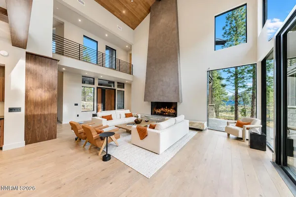 a living room with furniture fireplace and a large window