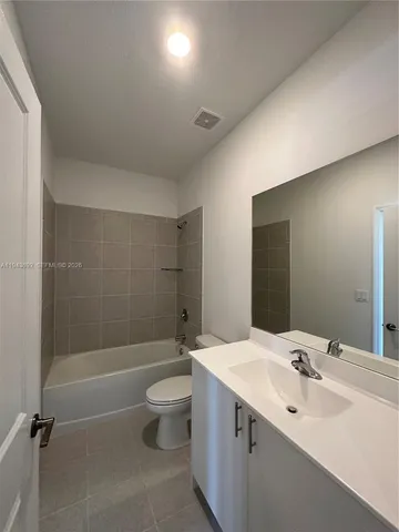 a bathroom with a bathtub sink and mirror