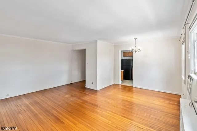 a view of a room with wooden floor and ceiling fan