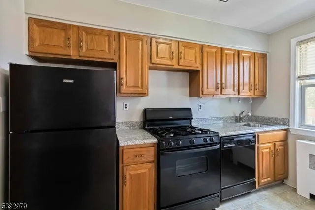 a kitchen with granite countertop a refrigerator stove and cabinets