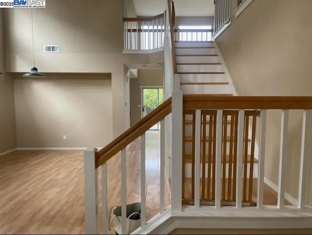 a view of staircase with lots of frames on wall and a window