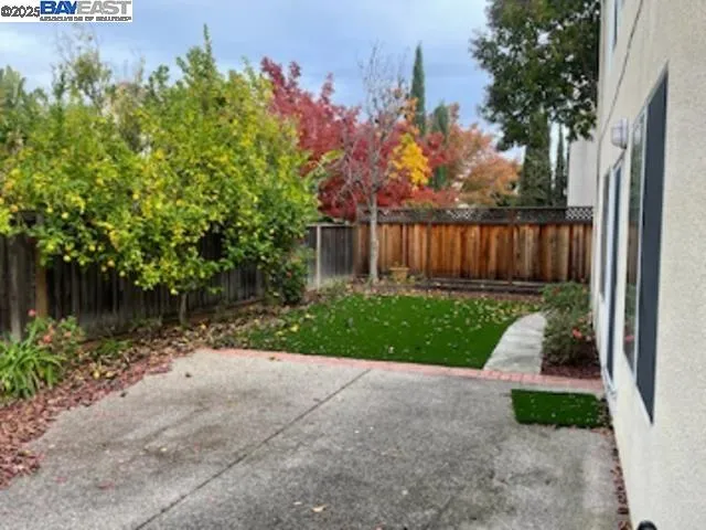 a view of backyard with potted plants and wooden fence