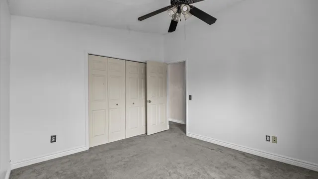 a view of a room with a ceiling fan