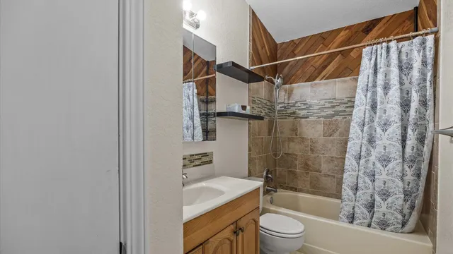 a bathroom with a shower toilet and sink