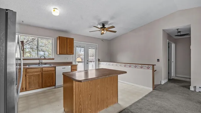 a kitchen with stainless steel appliances granite countertop a sink a stove and a refrigerator