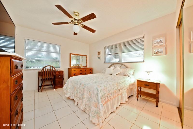438 Dover Road Tequesta, FL 33469 - Photo 8 of 10 a bedroom with a bed and a chandelier