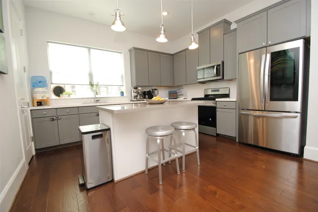 a kitchen with stainless steel appliances a stove a sink refrigerator and microwave