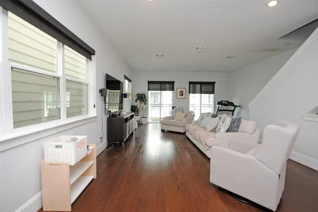 a living room with furniture wooden floor and a large window