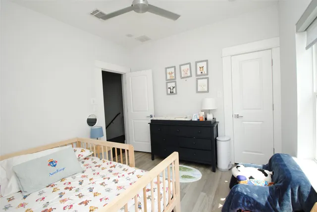 a bedroom with a bed and wooden floor