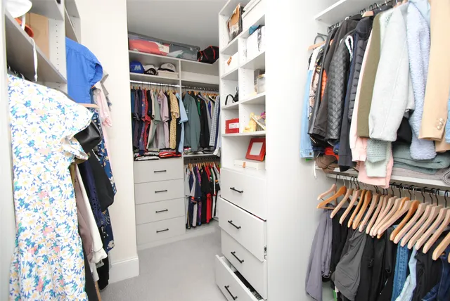 a view of walk in closet with clothes and shoes
