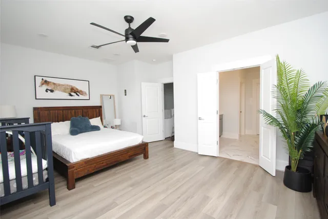 a bedroom with a large bed and a chandelier