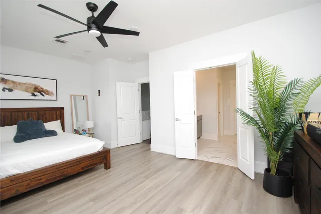 a bedroom with a bed and a potted plant