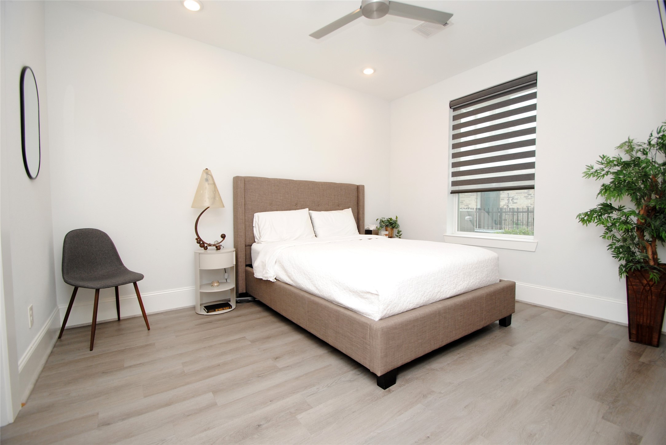 1262 North Post Oak Road, Unit B Houston, TX 77055 - Photo 7 of 44 a white bed sitting in a bedroom next to a window and a chair