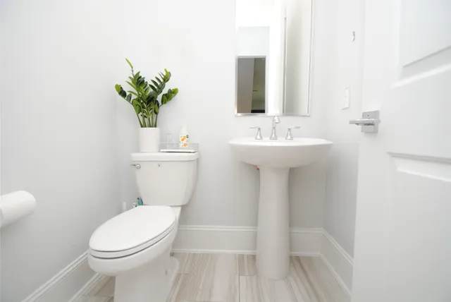 a bathroom with a sink toilet and mirror