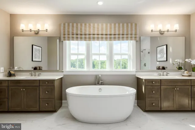 a bathroom with a tub sink double vanity and a mirror