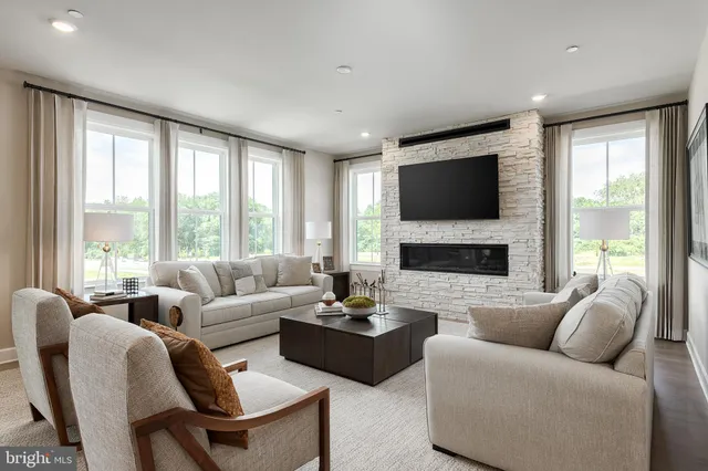 a living room with furniture a large window and a flat screen tv