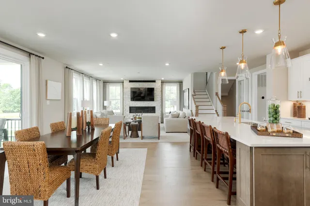 a dining room with stainless steel appliances kitchen island granite countertop a table and chairs
