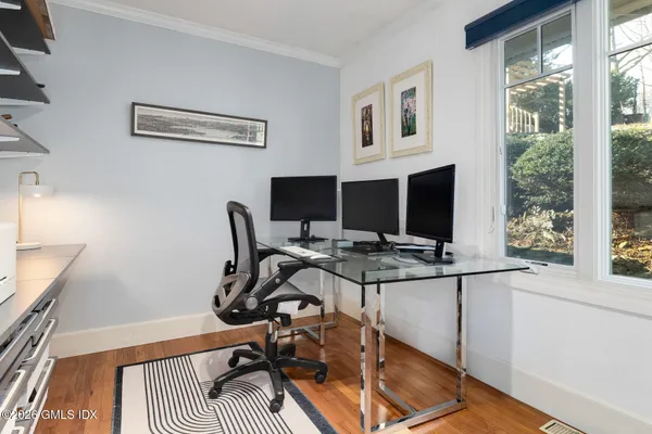 a view of a workspace with furniture and a window