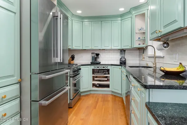 a kitchen with stainless steel appliances granite countertop a sink stove and refrigerator