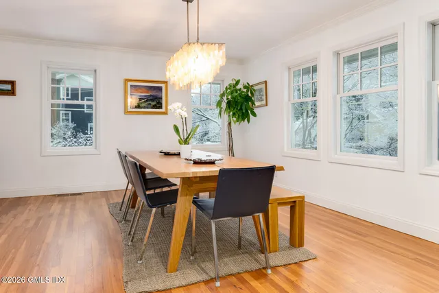 a view of a dining room with furniture a chandelier and wooden floor