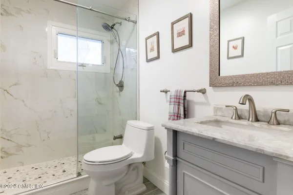 a bathroom with a sink a toilet and shower
