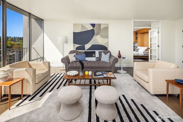 a living room with furniture a rug and a large window