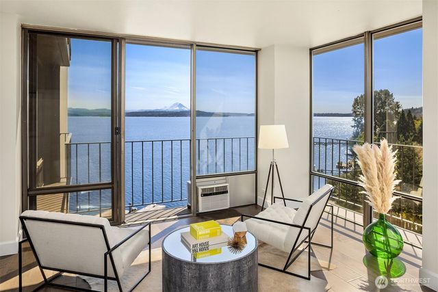 a living room with furniture a flat screen tv and floor to ceiling window