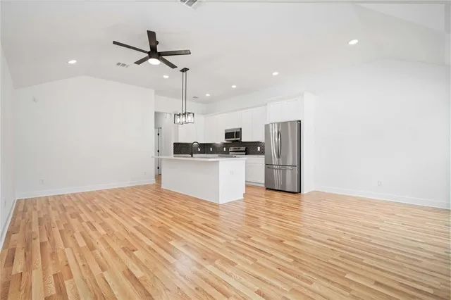 a view of a kitchen with a sink and wooden floor
