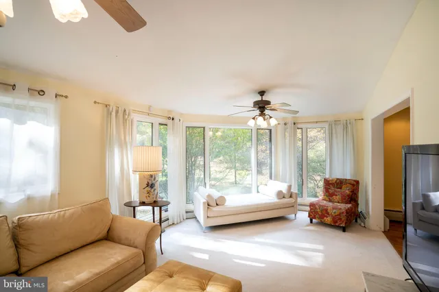 a view of a hallway with wooden floor and living room
