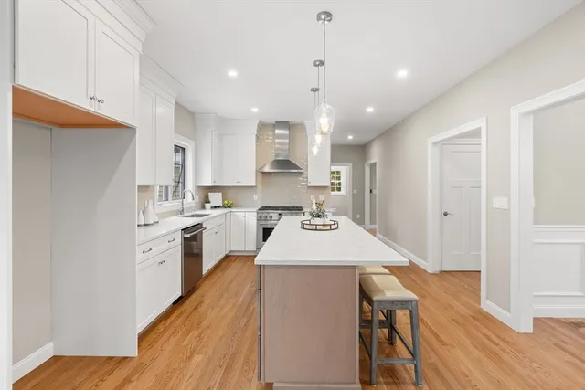 a kitchen with a sink a counter top space stainless steel appliances and cabinets