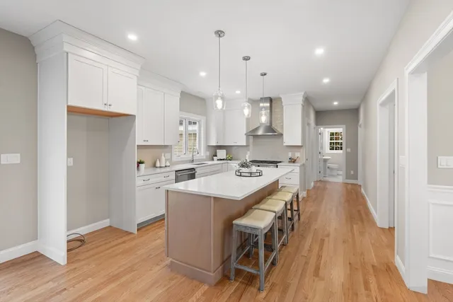 a kitchen with a sink a center island stainless steel appliances and cabinets