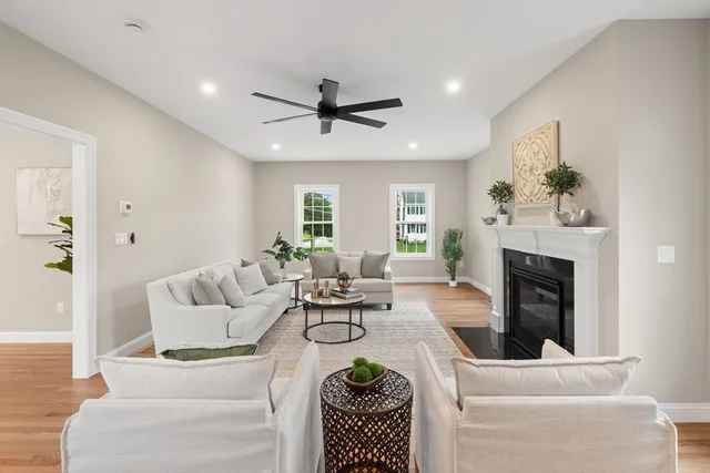 a living room with furniture a fireplace and a window