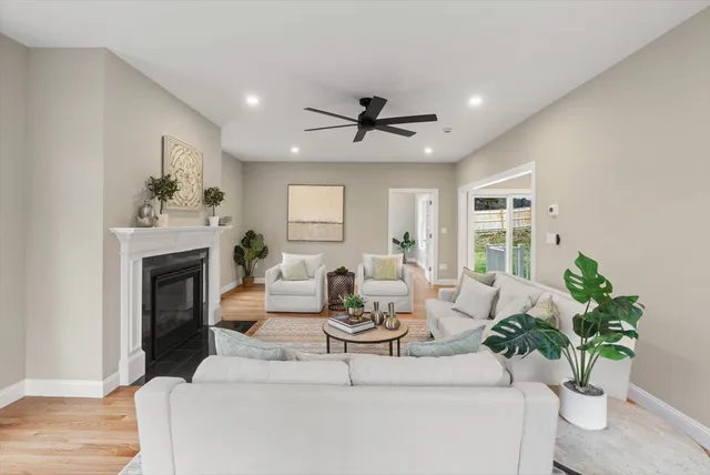 a living room with furniture a fireplace and potted plants