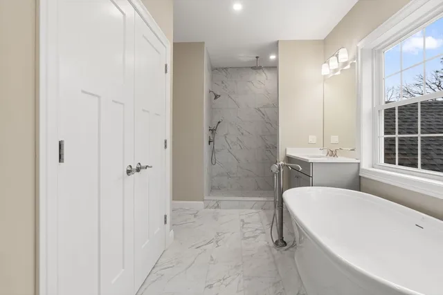 a bathroom with a granite countertop sink mirror and a bathtub