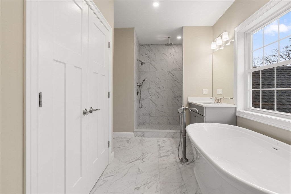 103 Central Street Andover, MA 01810 - Photo 31 of 42 a bathroom with a granite countertop sink mirror and a bathtub