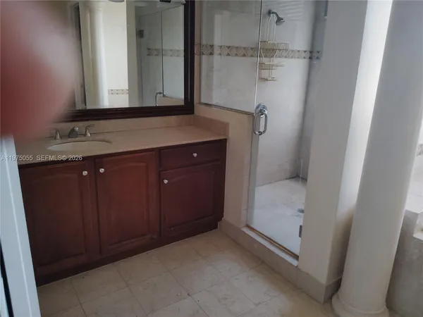 a bathroom with a granite countertop sink a mirror and a bathtub
