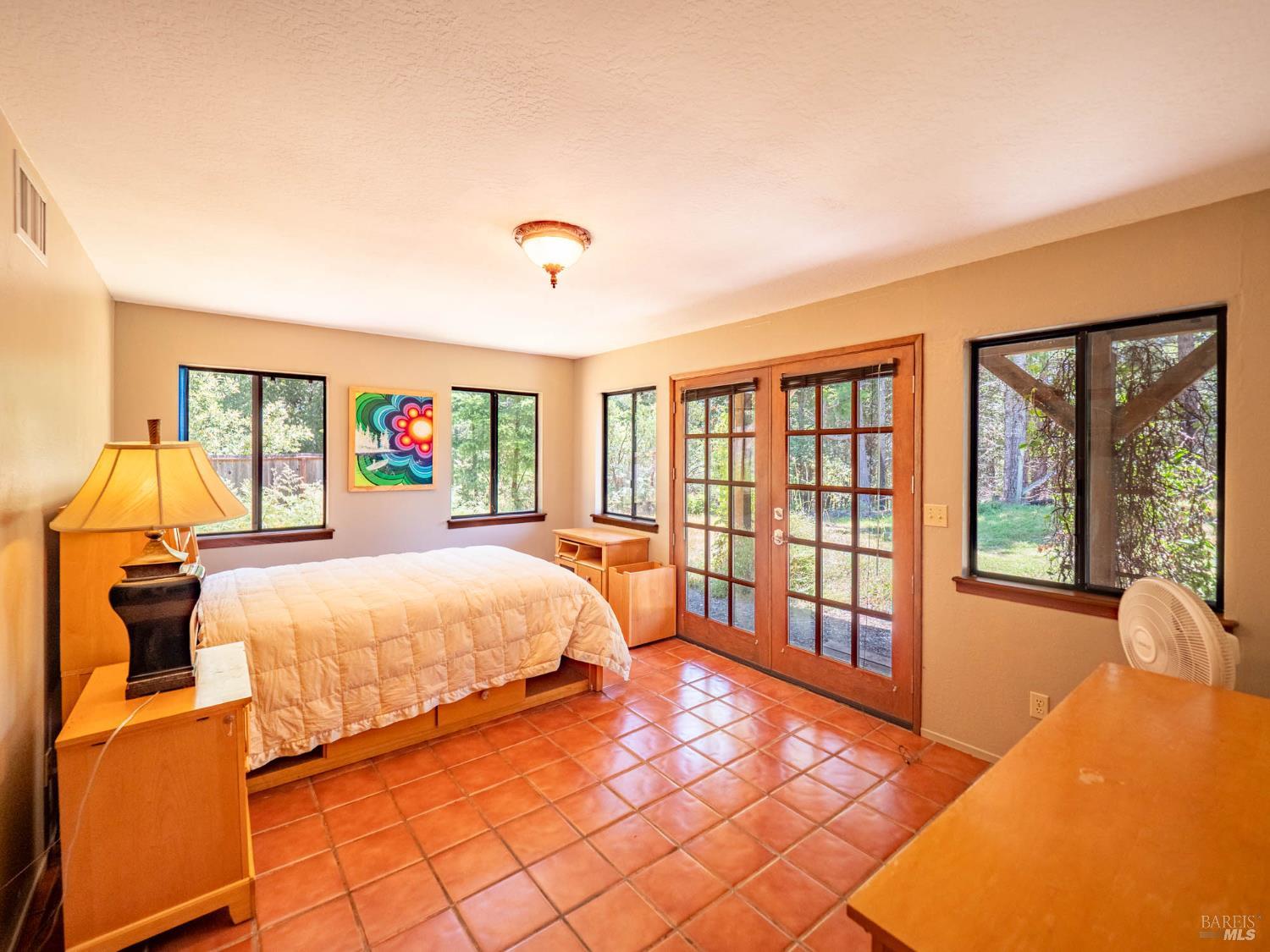 7701 Signal Ridge Road Philo, CA 95466 - Photo 17 of 32 Spacious bedroom on the lower level. The french doors provide private outdoor access—ideal for guests, or multi-generational living.